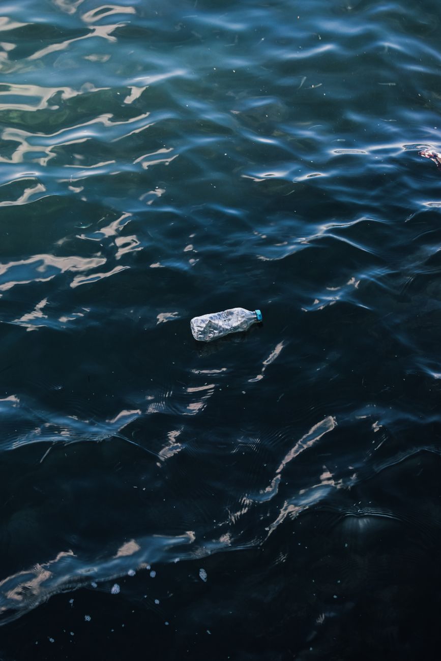 A floating marine barrier collecting ghost nets and plastics in open blue water