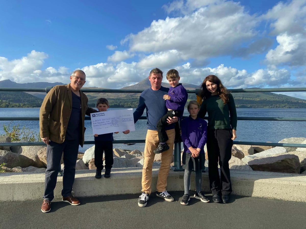 Thomas presents ArCaS chairman Michael Dobson with a cheque alongside his mum Paula McGuire, father Piotr Kowal, sister Clara and brother Andrew. Photograph: Supplied.